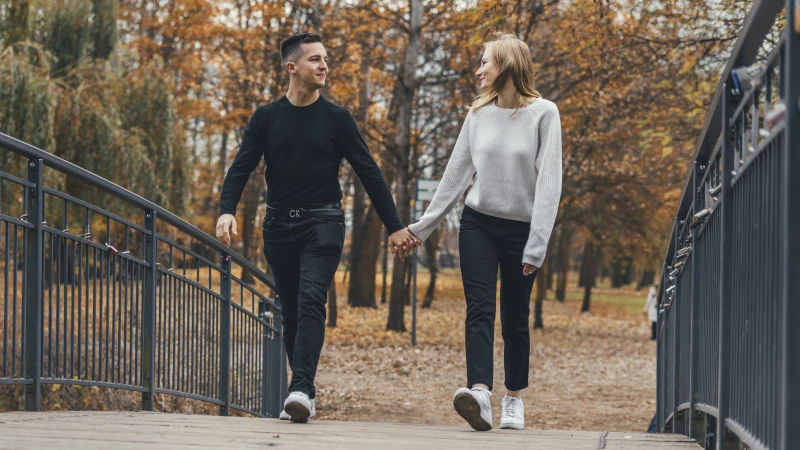 Fotografia par w Toruniu – jesienna sesja rocznicowa zakochanej pary spacerującej po moście