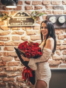 Jubilatka z bukietem czerwonych róż podczas urodzin w Toruniu