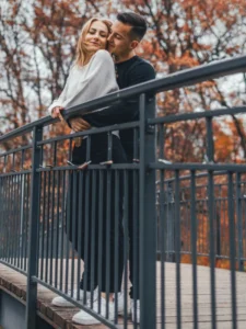 Plenerowa sesja narzeczeńska w Toruniu – zakochana para na moście w jesiennej scenerii