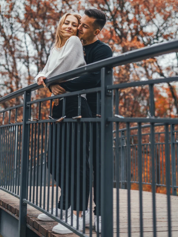 Plenerowa sesja narzeczeńska w Toruniu – zakochana para na moście w jesiennej scenerii