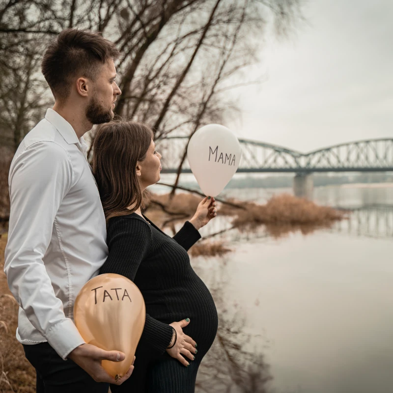 Plenerowa sesja rodzinna i ciążowa w Toruniu – przyszli rodzice z balonami mama i tata