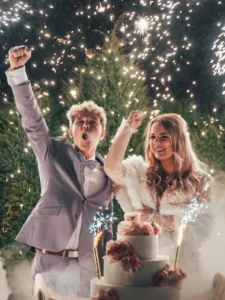 Reportaż weselny – para młoda przy torcie weselnym z pokazem fajerwerków