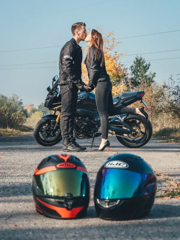 Sesja narzeczeńska w Toruniu – para motocyklistów całująca się przy motocyklu z kaskami na pierwszym planie